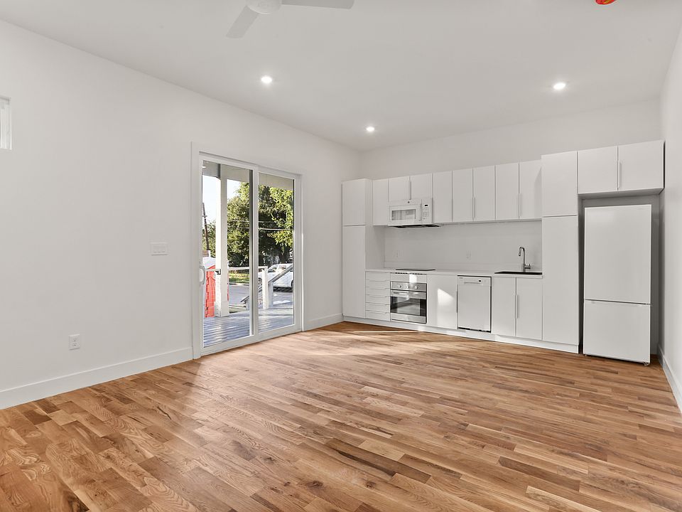 Main living area filled with natural light, modern kitchen and cabinets and solid White Oak floors.