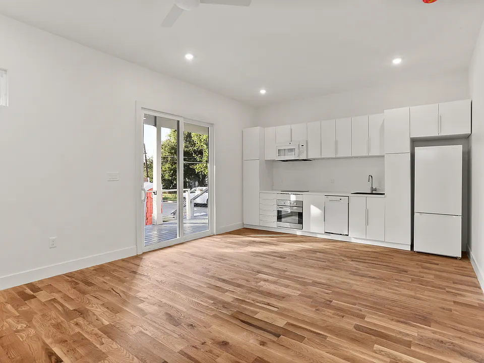 Main living area filled with natural light, modern kitchen and cabinets and solid White Oak floors.
