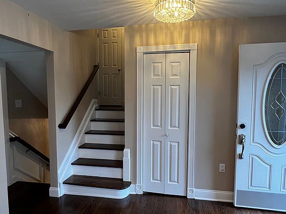 Entryway with coat closet and stairs to bedrooms