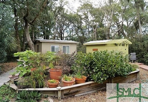 Studio and outdoor shower with wooden walkways leading to both.