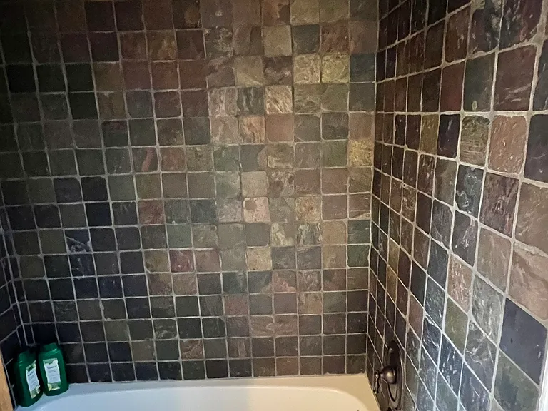 Shower in tub next to upstairs bedroom