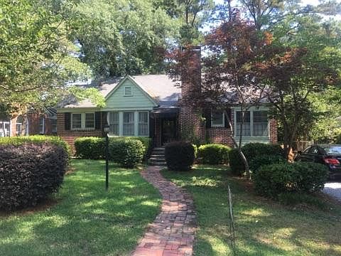 Front view of house. Gravel driveway on the right.