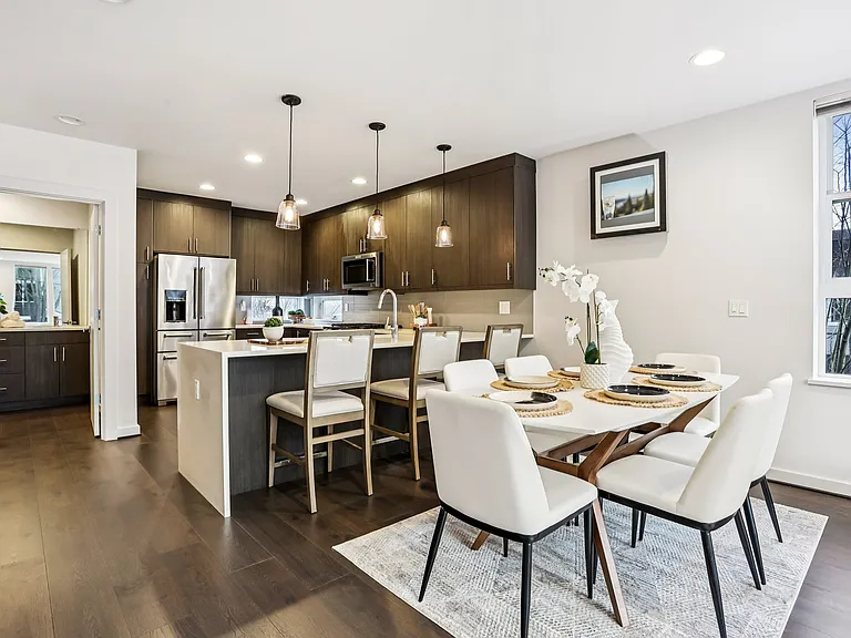 Chef's kitchen with large island, quartz waterfall counter, modern cabinets and high quality appliances.