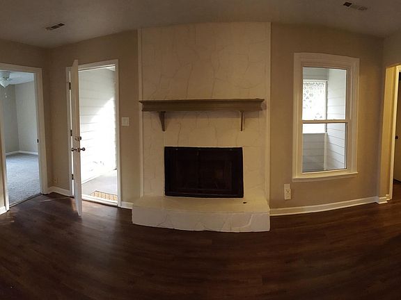 Living room with gas fireplace overlooking screened porch. 