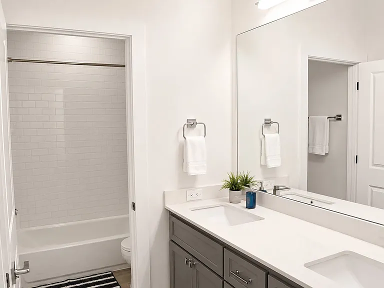 Contemporary bathroom with a dual vanity featuring white countertops and gray cabinetry