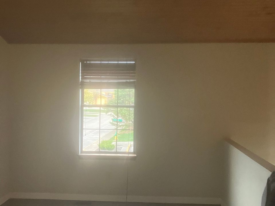 Living room showing wall overlooking stairs and doorway, vaulted wooden ceiling and living room window