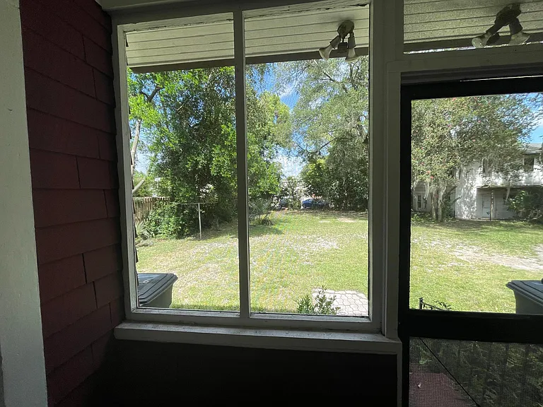 View out of the screen porched to the backyard which is the parking area.