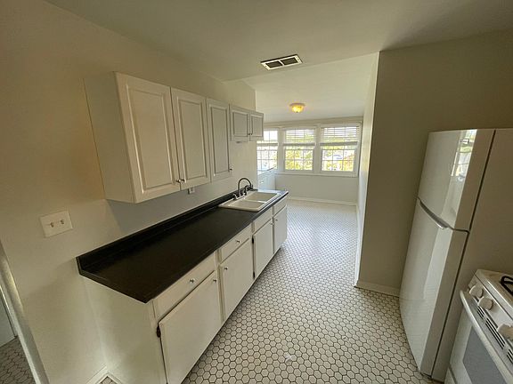 Long galley kitchen with fridge stove/oven and plenty of storage