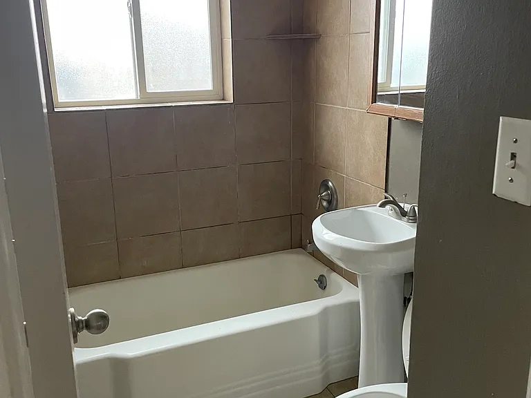 Bathroom with large frosted window to backyard