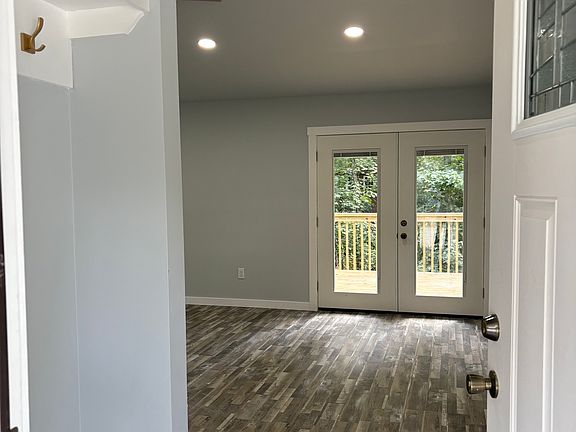 Entry has a custom sitting storage bench and coat hanging with beautiful chandalier