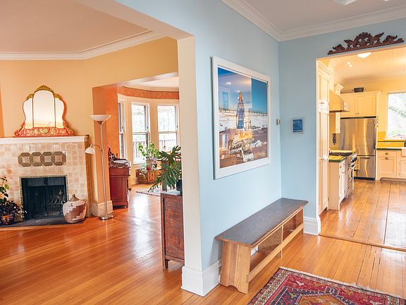 Welcoming foyer and open plan first floor. Renovated kitchen and decorative fireplace.