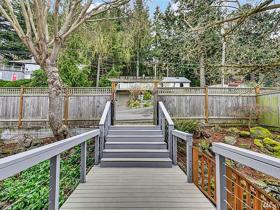 Reverse angle from front door, footbridge to street/gate. Majestic old-growth trees on the surrounding hillside give a distinctly northwest feel. 