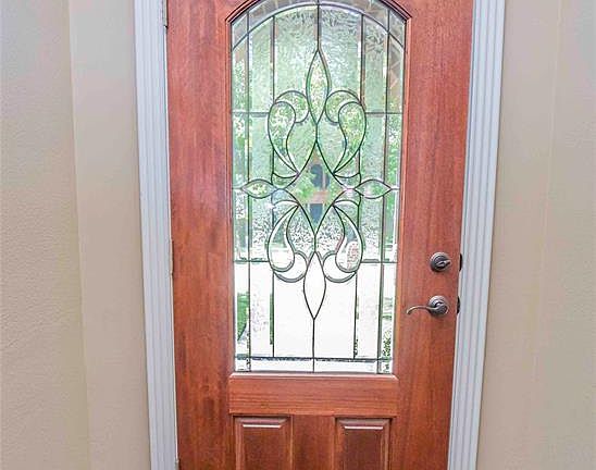 Striking white trim and 6" base boards pop against the wood and lead glass front door.