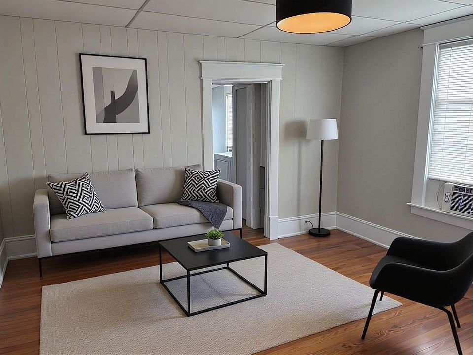 Spacious Living Room with Original Harwood Floors, Designer Lighting and New Sherwin Williams Ammonite Gray Paint Throughout.