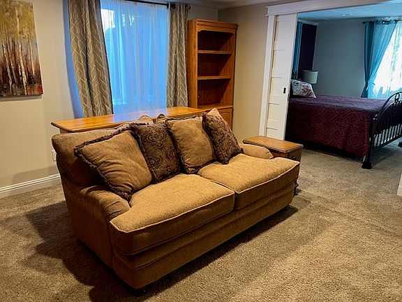 Huge egress window in living room with a deep comfortable couch. Bedroom can be closed off with pocket doors