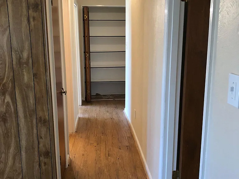 Hallway with large linen closet at end.