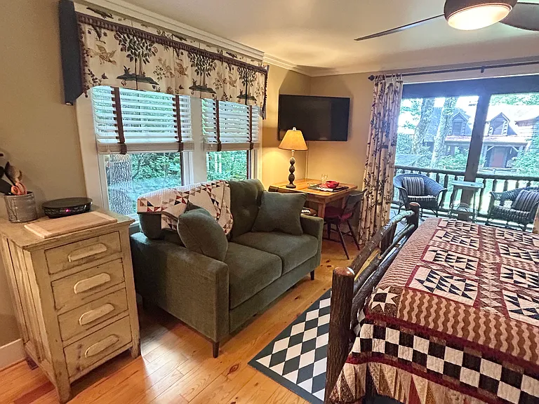 Loveseat for lounging, smart TV, and desk area.