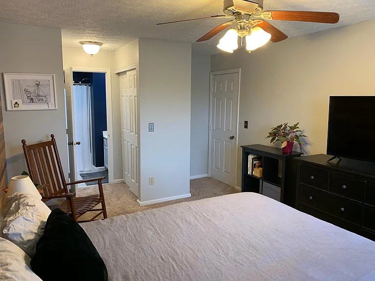 Spacious master bedroom with a gorgeous wood accent wall and ensuite bathroom.