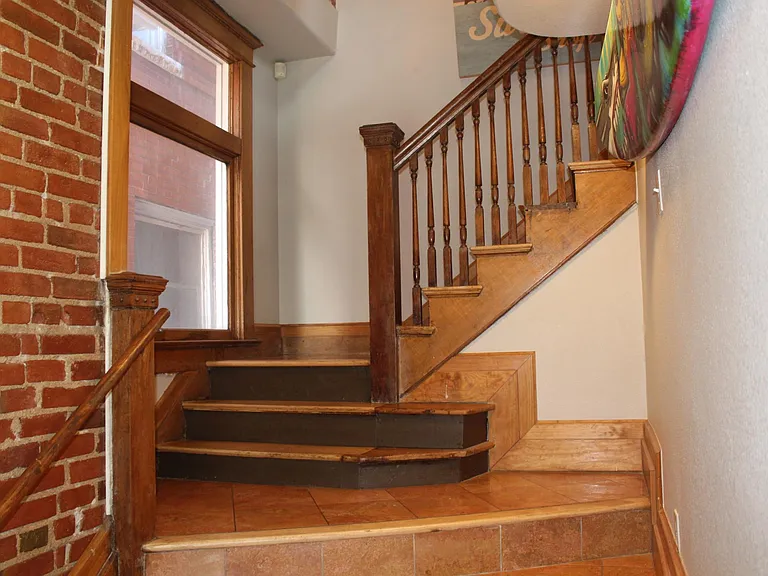 Front entrance with exposed brick and 1906 banister