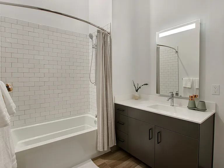 Serene bathrooms with quartz countertops and edge-lit mirrors