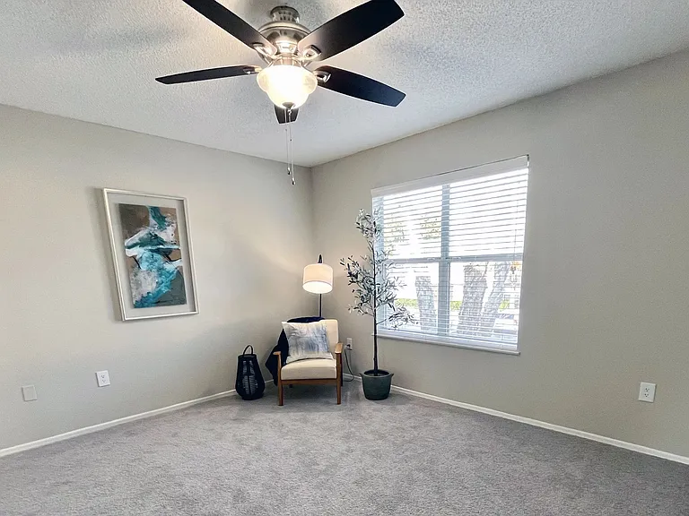 Reign over a spacious master suite with plush carpeting, a ceiling fan, and a regal ensuite.