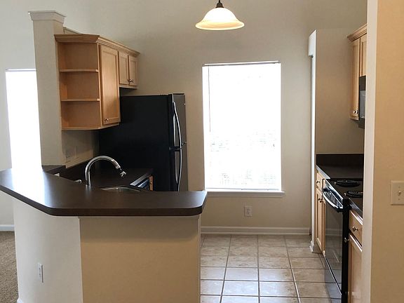 Open Kitchen with black on black appliances and under cabinet lighting.