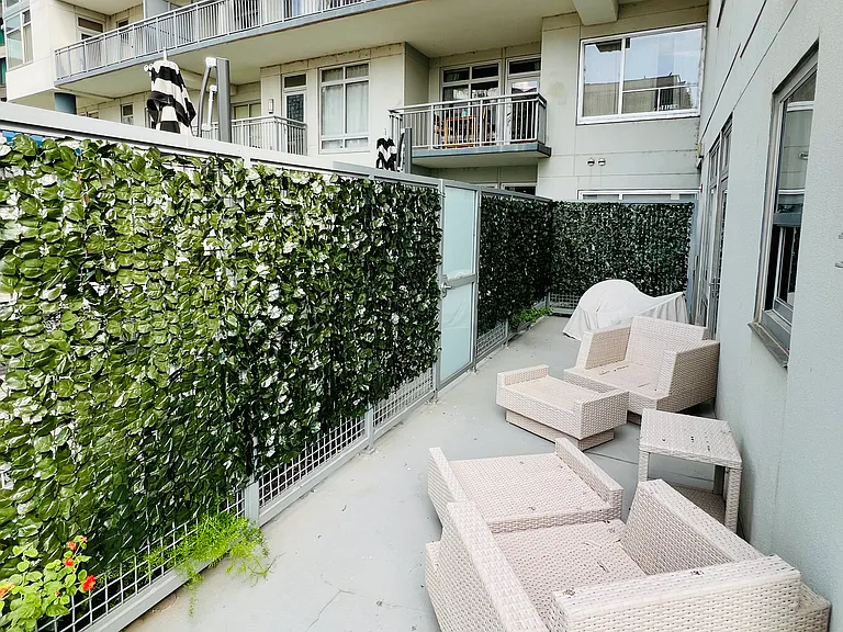 Another view of the large, one of a kind patio; privacy vines cover the majority of the area but open at the opposite end to check out pool deck activity; secure patio door leads to the amenity deck.