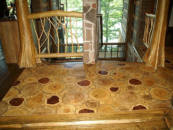 Foyer with unique flooring using slices of area tree trunks (only dead trees are used for these purposes), cypress columns and cedar limbs are incorporated into the railing.