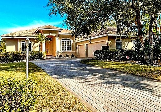 Front of Mediteranean style Ranch home with 3 car garage.
