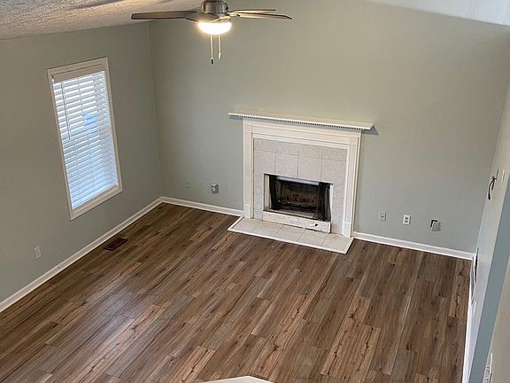 Top of stairs looking down into den. Wood burning fireplace.