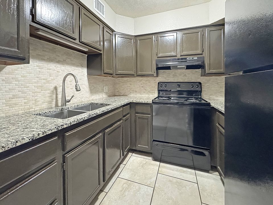 Contemporary kitchen design featuring dark cabinets and durable counters at Los Cedros Apartments in Brownsville, TX.