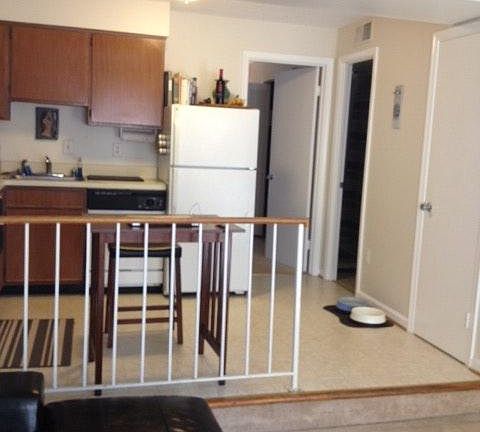 This kitchen is undergoing renovation. The cabinets, countertop and floors will be replaced. New refrigerator. Railing removed.