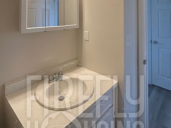 Lower Half Bath viewed from inside looking toward Passageway between Living Room and Dining/Kitchen.
