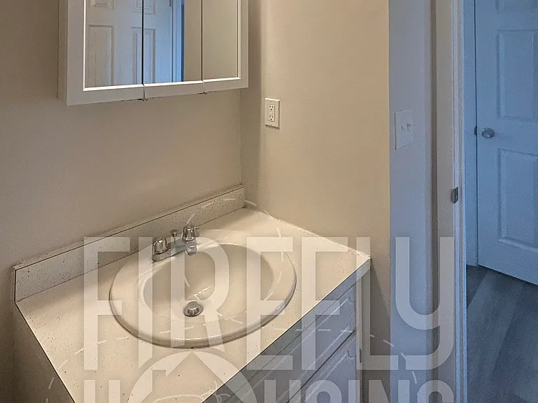 Lower Half Bath viewed from inside looking toward Passageway between Living Room and Dining/Kitchen.