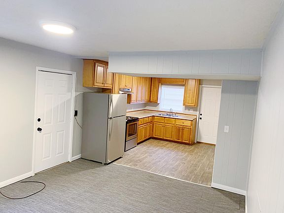 Kitchen with new stainless steel appliances. Window looks onto back porch and large backyard surrounded by woods.
