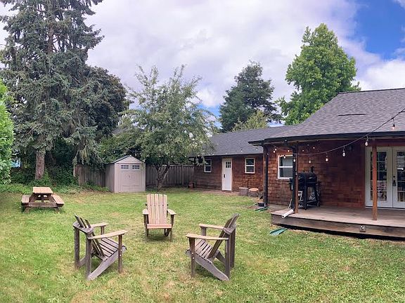 Backyard w/ covered porch and detached workshop in the back right corner.