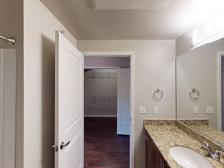 Apartment bathroom with wood-style flooring.