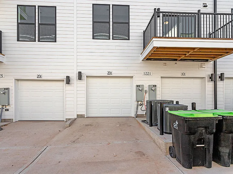 back of unit with 1 car garage and driveway.