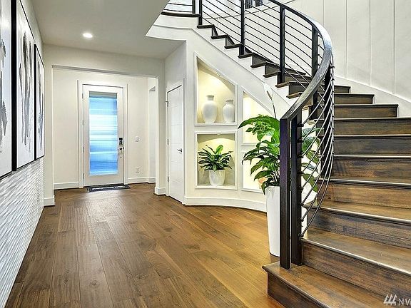 Elaborate curved stairs in elegant entryway. Photo not of actual home - may contain optional features.