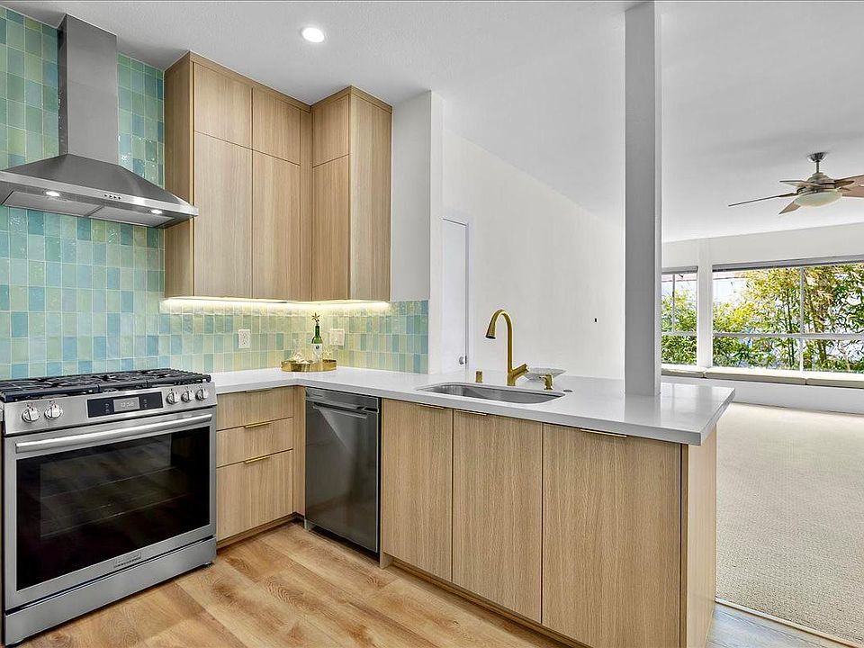 Pale oak cabinets, Spanish tile backsplash in a beach glass palette, and fab stainless appliances.