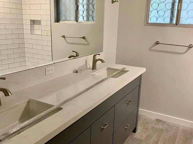 Primary bath w/vinyl flooring, quartz counters, custom vanity, designer tile
