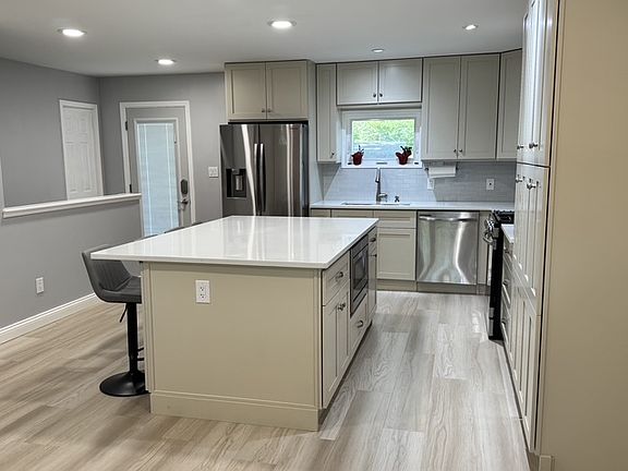Kitchen with Gas Range with exhaust hood, built-in Microwave, Dishwasher and ample pantry space.