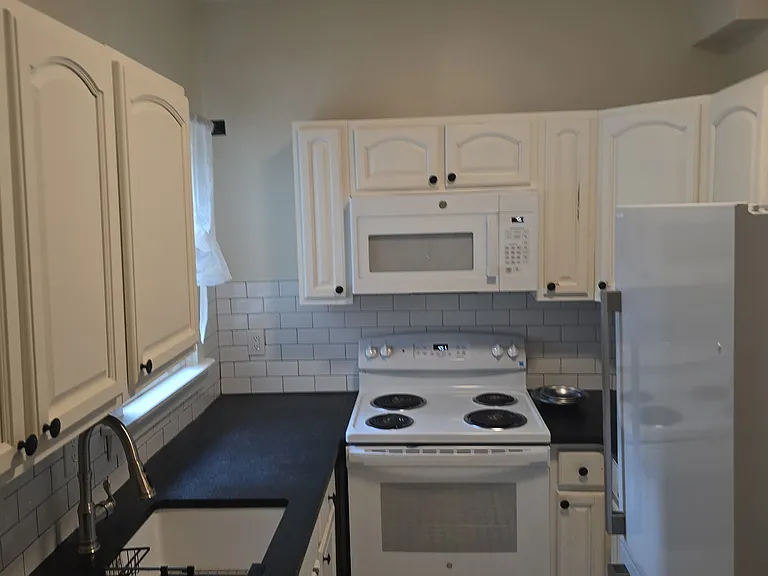 Remodeled kitchen with new appliances, granite and decorative tile flooring.