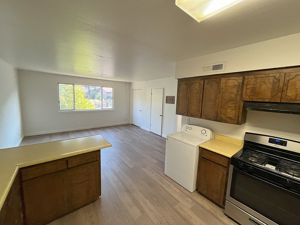 Looking through the kitchen into the main living area. Front door is to the right of the window.