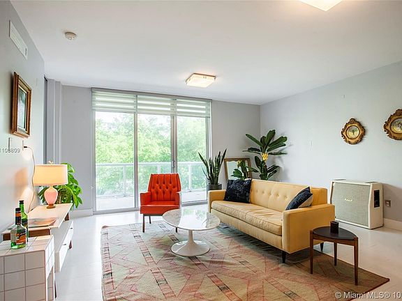 Living room with adjacent balcony. Impact windows and window treatments. 