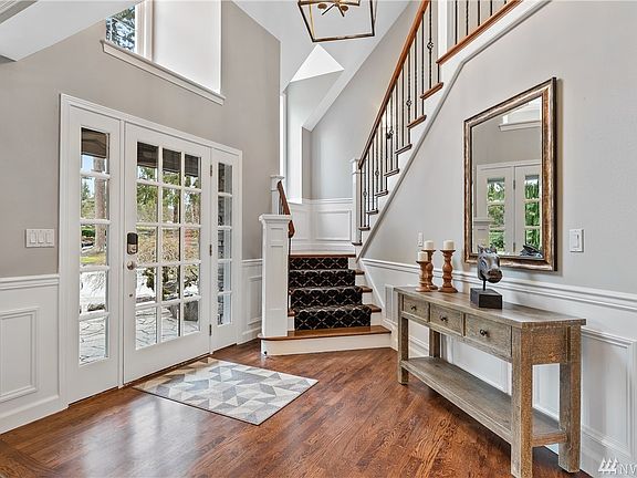 The beveled glass 2 story foyer with wainscoting and side turned iron stairway with new textured neutral carpet on the stairs (being installed soon). 