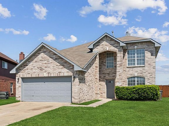 View of front facade with a garage and a front lawn