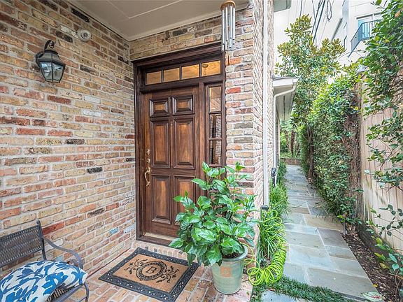 Covered entrance space has room for a bench and shows the access to the side yard and patio. The solid wooden door has glass detains both above and along the side of the door. A significant wooden fence is present along the entire west side of lot. A