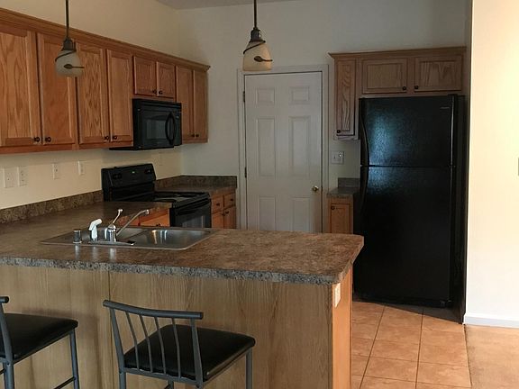 Tile flooring. Black appliances including dishwasher. Electric stove. Two barstools with rental.