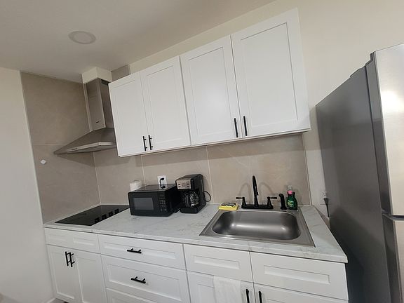 The kitchen includes a refrigerator, coffee maker, extractor hood and basic amenities